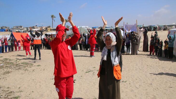 A Palestine Red Crescent psychosocial support team member (right) next to an Egyptian Red Crescent volunteer during a recreational activity for displaced children in Rafah, Gaza